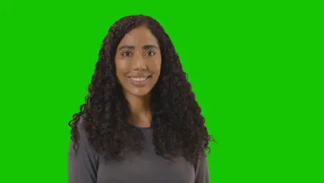 Portrait Of Woman Against Green Screen Smiling At Camera