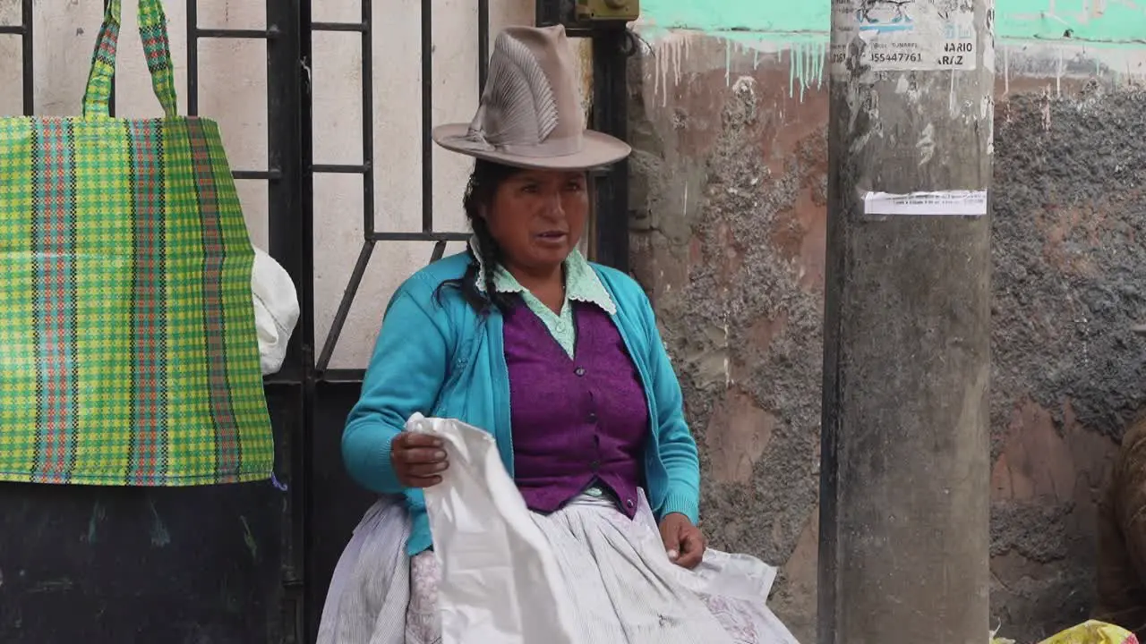 Local Peruvian Women Wearing Traditional Hat In Street With People Walking Pas