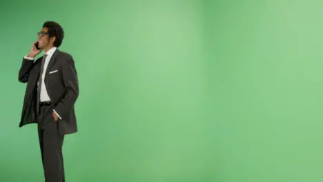 Smiling Businessman walking with phone on green screen