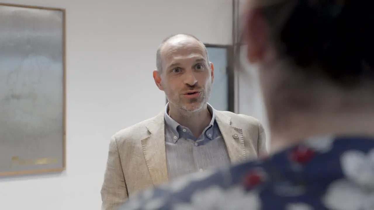 Slow motion shot of business partners speaking to each other in the corridor