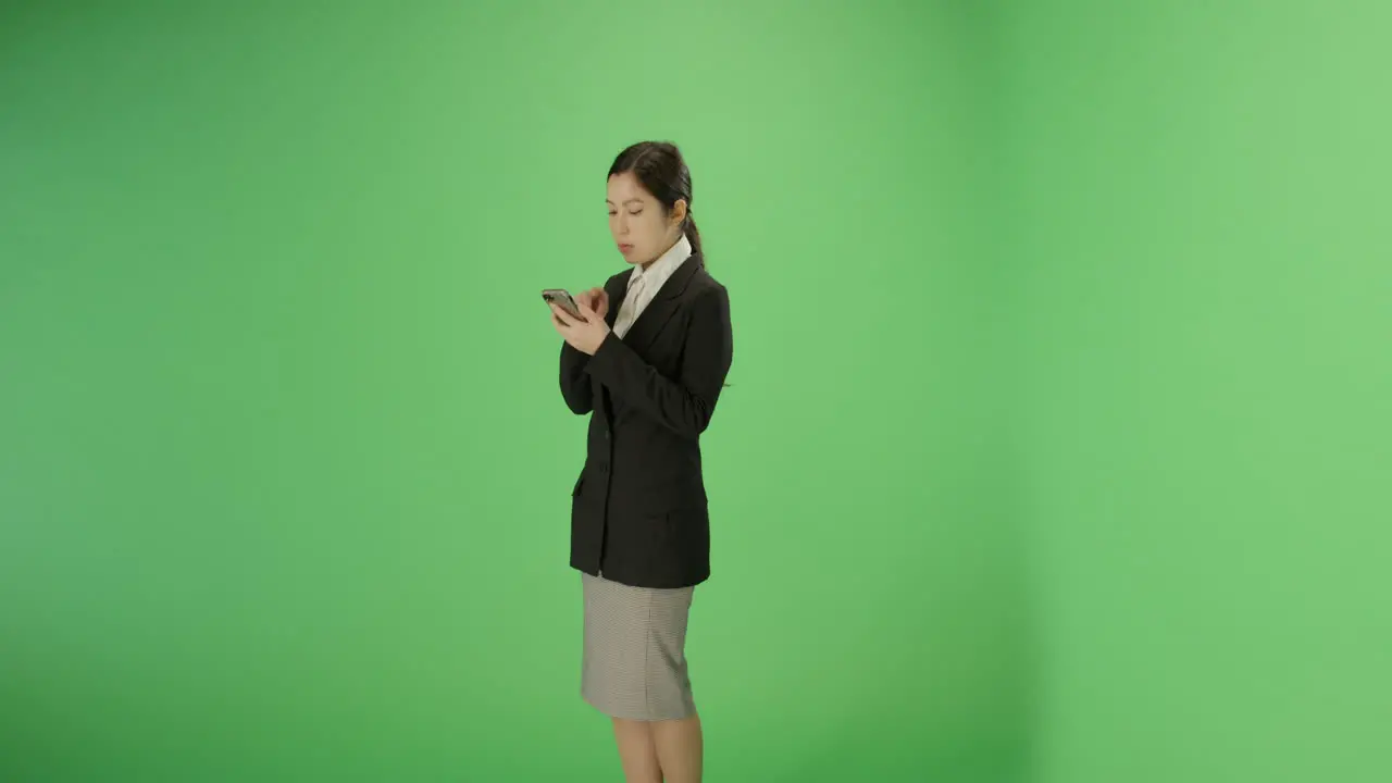 Businesswoman texting on phone with green screen