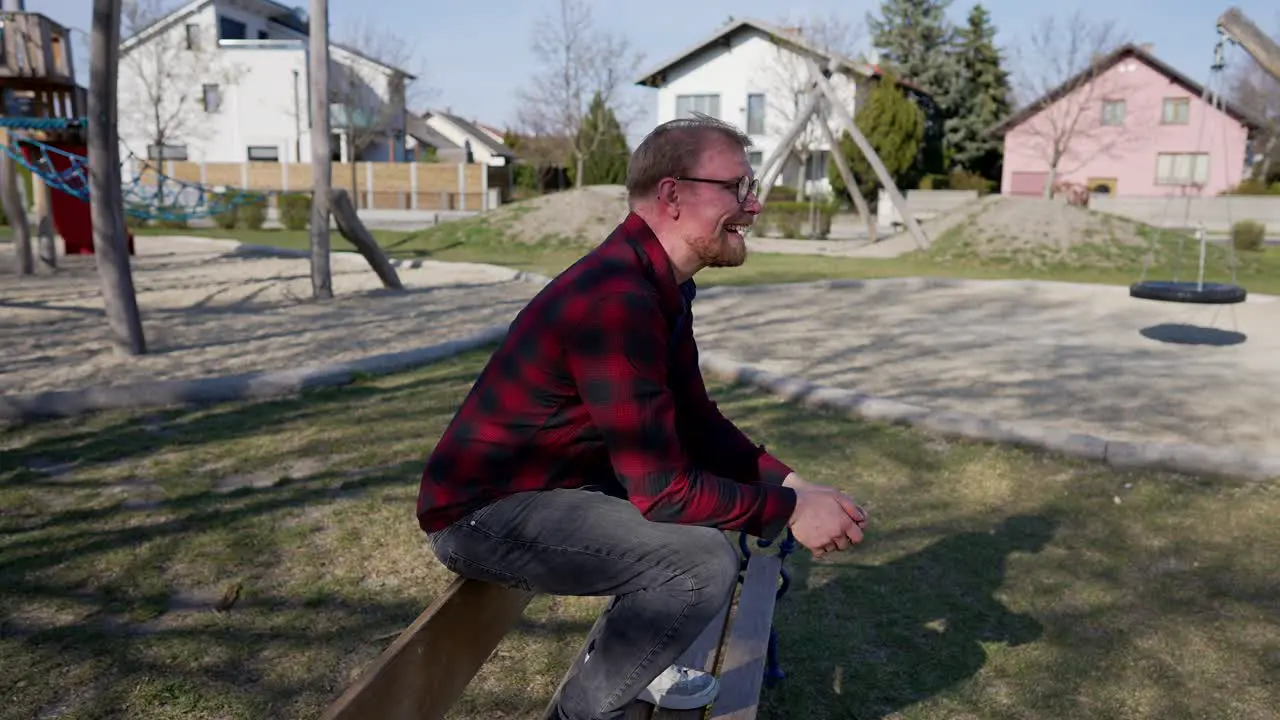 Happy Young Man Jumps Over Bench in Park and Sits Smiling Person in Medium Shot