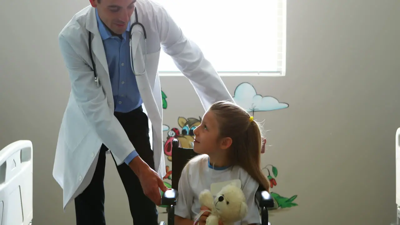 Médico Varón Interactuando Con Un Paciente Infantil En La Sala