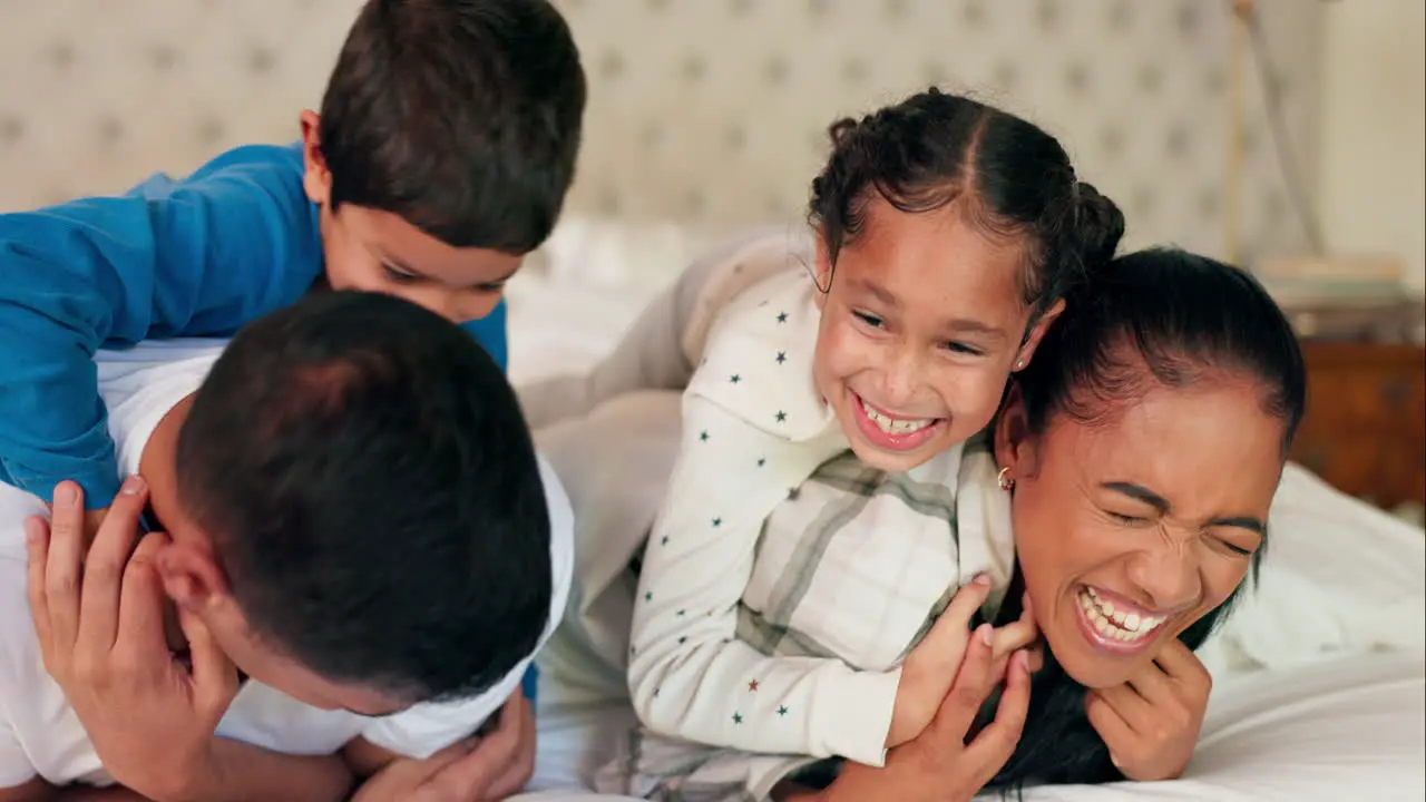 Mother father and happy kids on bed