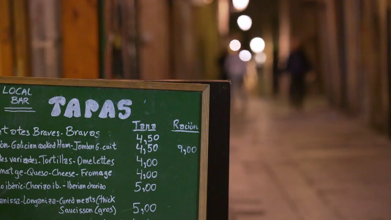 Local Bar Restaurant Tapas Menu on Blackboard on Streets of Barcelona Spain at Night Handheld