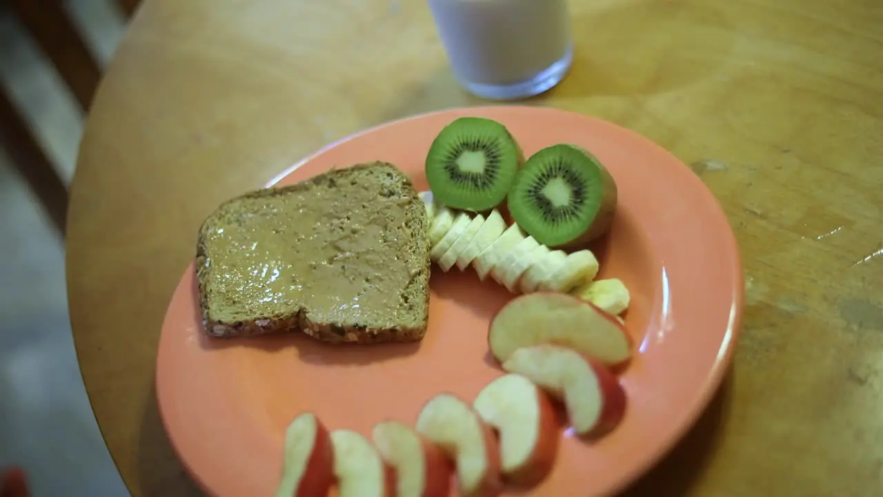 Slow Motion shot of someone setting a plate full of breakfast food on a wooden table