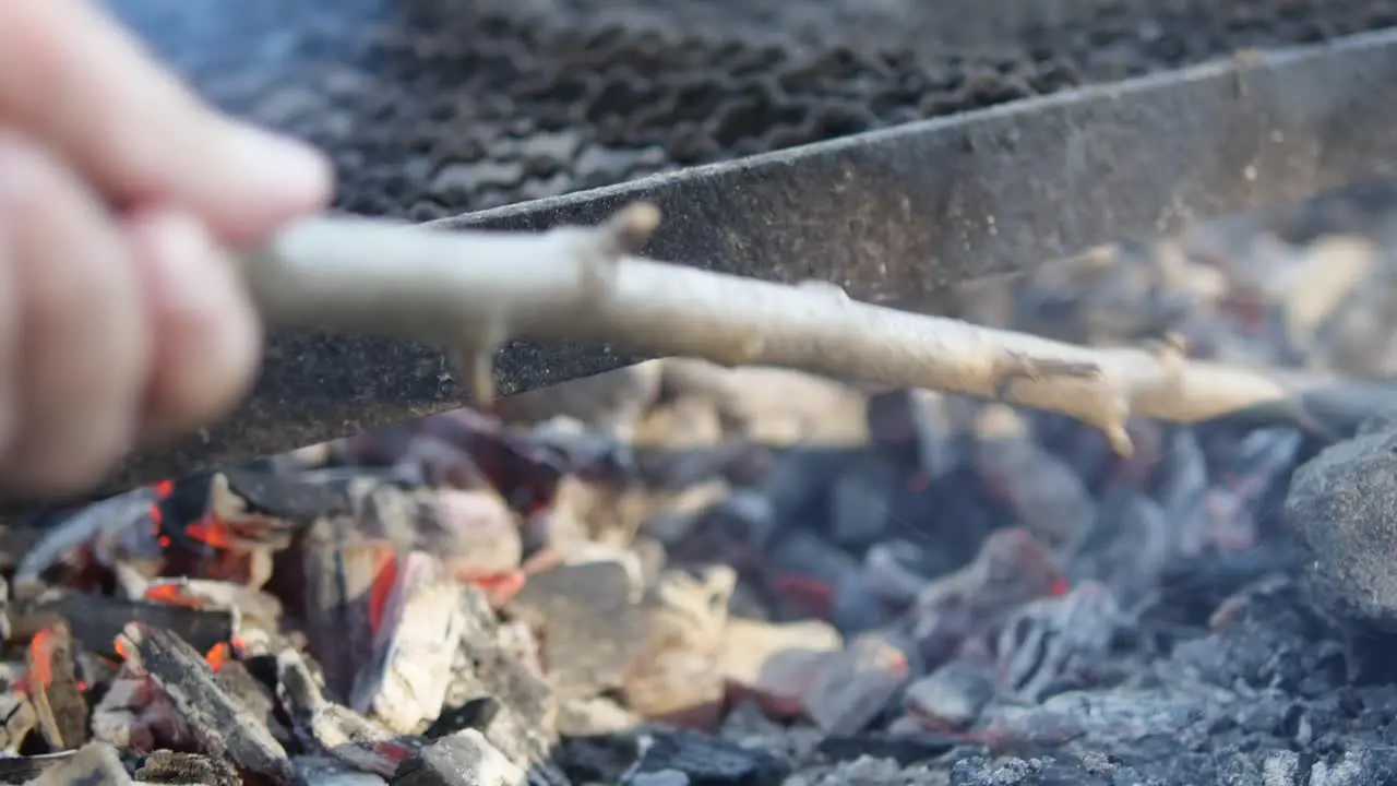 A bbq is being prepared using fuming hot coal