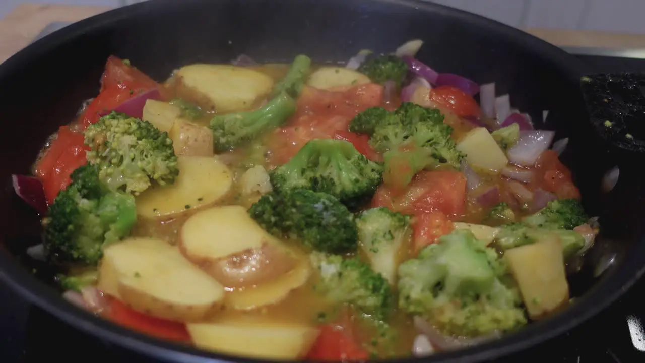 Close up of making scrambled eggs with vegetables in a frying pan