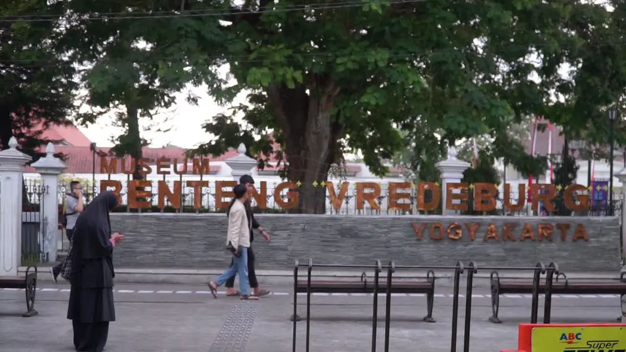 The Signage "Benteng VREDEBURG Yogyakarta" on the gate of VREDEBURG Fortress with people walking past Yogyakarta Indonesia