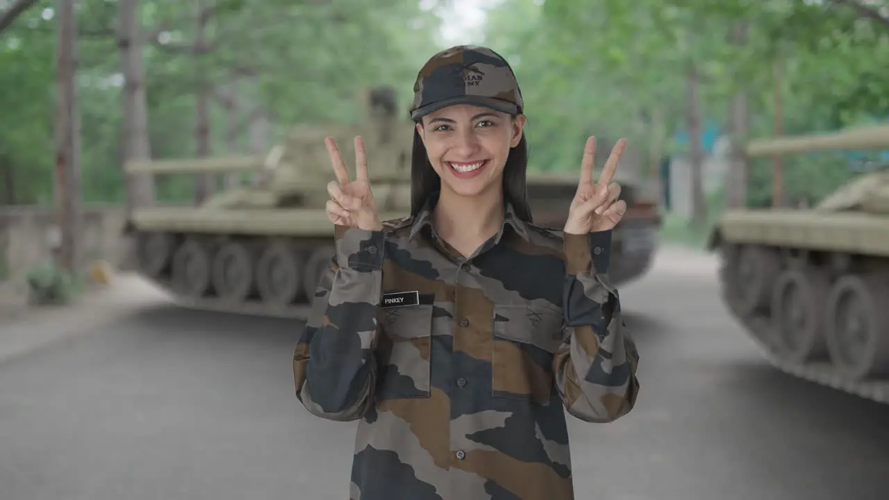 Happy Indian woman army officer showing victory sign