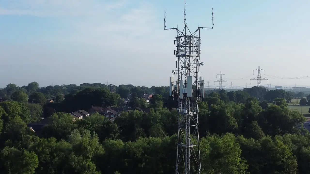 5G broadcasting tower antenna in British countryside woodland landscape aerial dolly rising right view