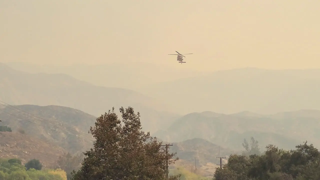 Large Helicopter taking water from lake to put out large fire at Fairview Fire Hemet California USA