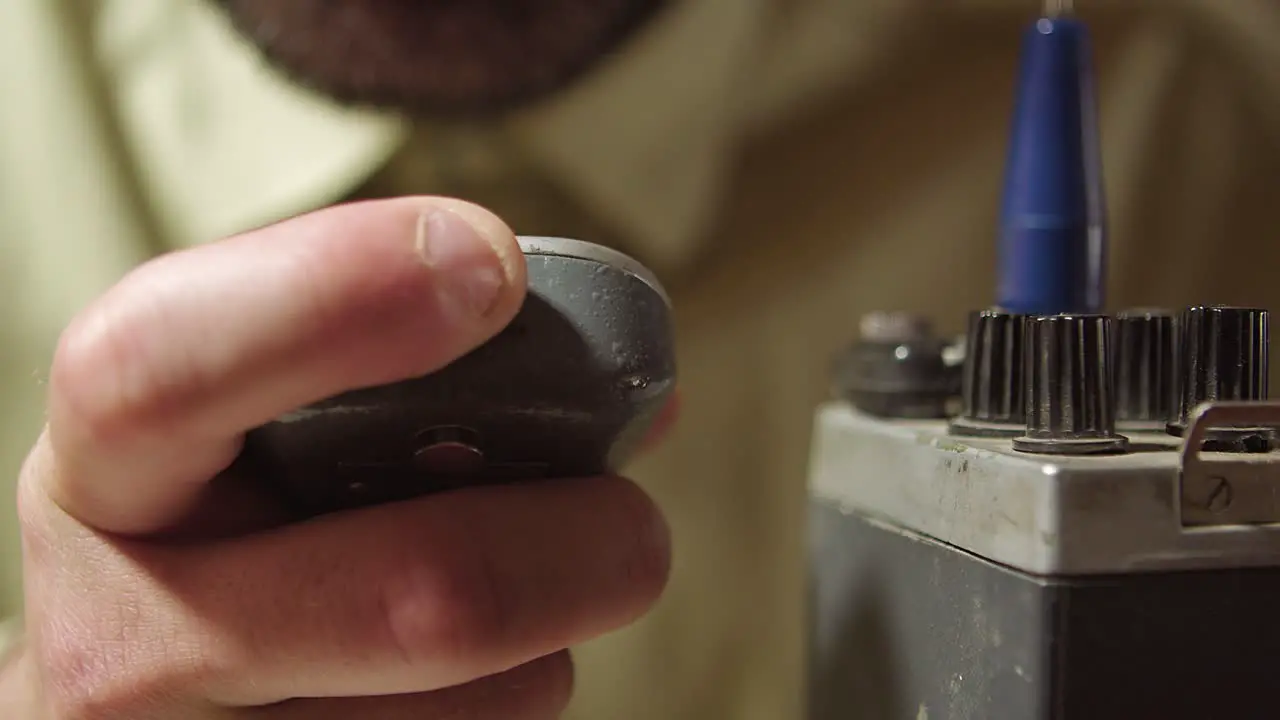 Tuning old walkie talkie extreme closeup of finger speaking and using it