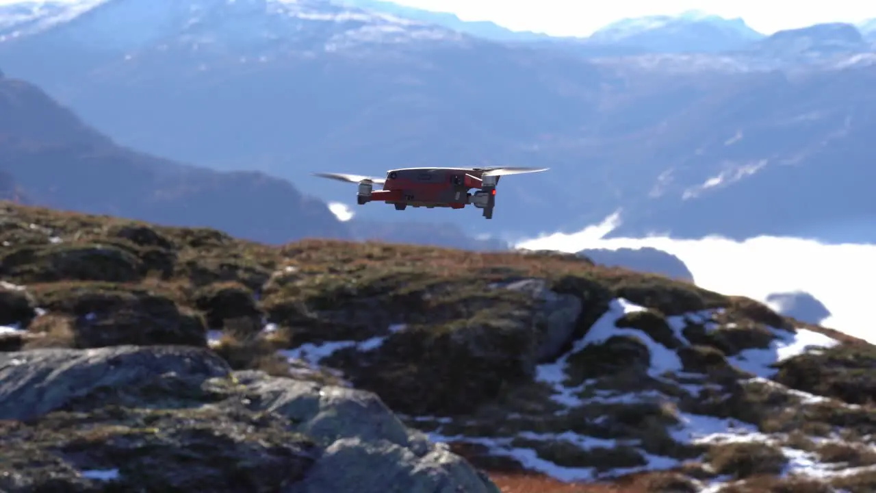 Modern drone hovering in front of camera before rotating and flying away to disappear into vast mountain landscape Nesheim mountain in Vaksdal Norway Dji mavic 2 drone with Hasselblad camera