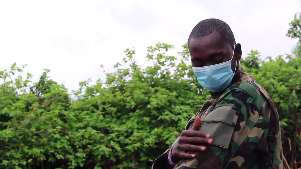 African soldier man going over his uniform with covid mask on