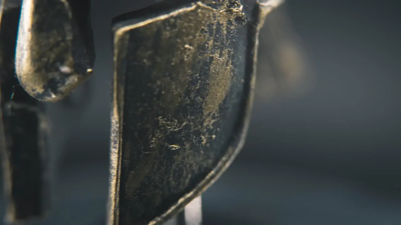 A close up macro detailed pan right shot of a spartan face design warrior ancient greek bronze helmet on a 360 rotating stand studio lighting 4K smooth movement