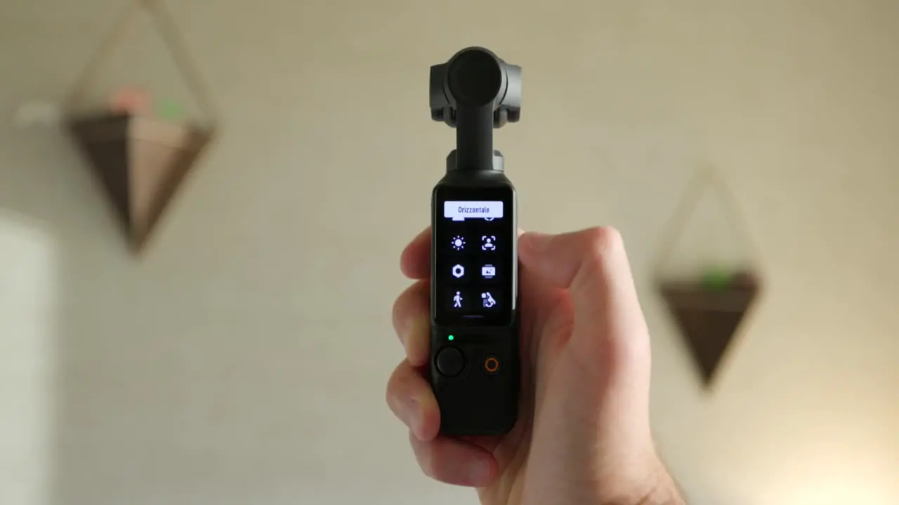 Close Up View Of DJI Osmo Pocket 3 Held In Hand And Screen Being Flipped From Vertical To Landscape Mode And Scrolling Through Screen Icons Indoors