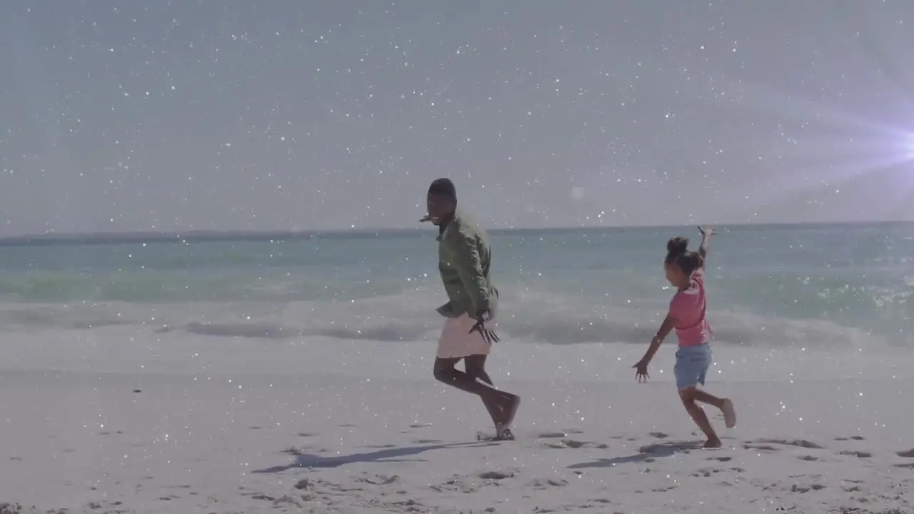 Animation of light trails over african american man and his daughter at beach