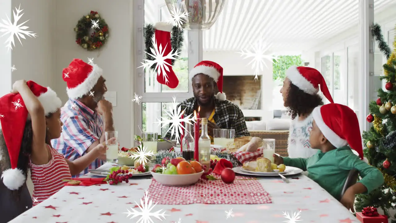 Animation of snow falling over african american family having dinner