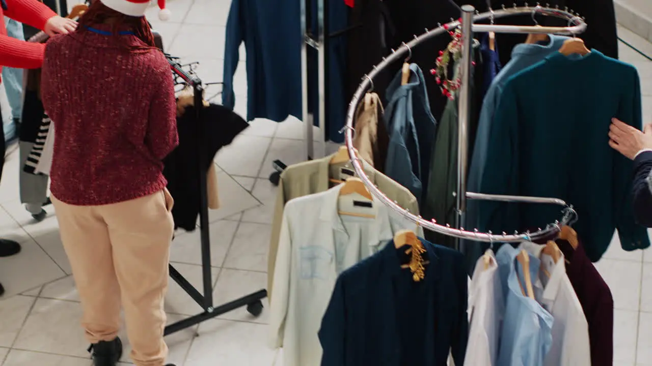 Bustling festive ornate clothing shop filled with customers in xmas frenzy looking to buy ideal presents family members Clients in shopping spree at mall boutique during Chrismtas holiday season