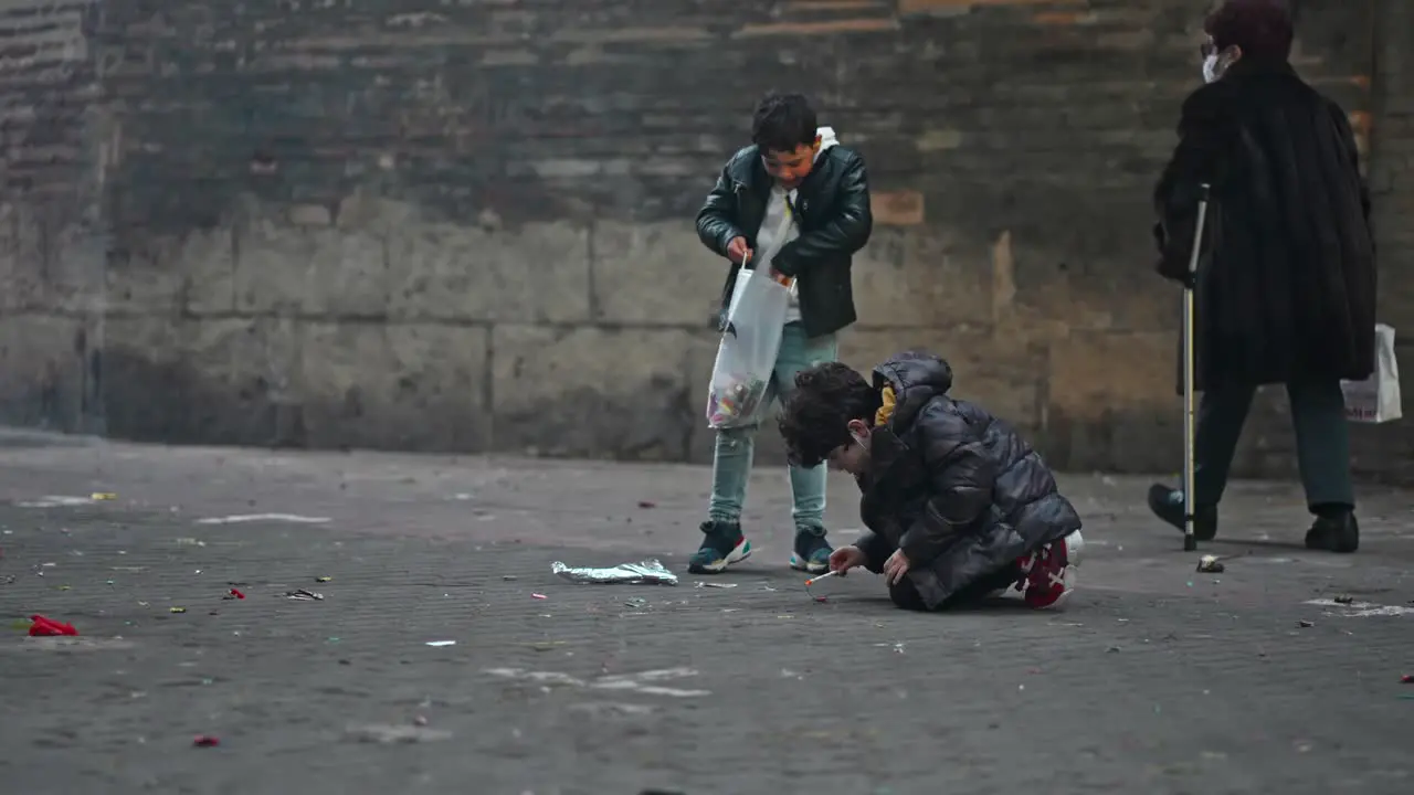 Group of children playing with fireworks and firecrackers in the street of Valencia during "Las Fallas" traditional festival