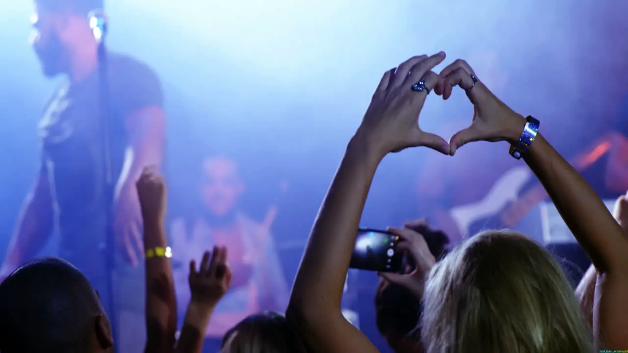 Woman forming heart shape during stage show 4k