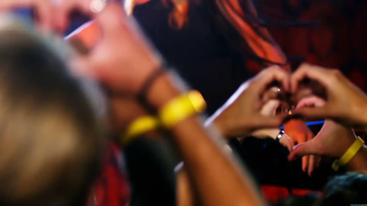 Hands of audience forming heart shape during stage show 4k