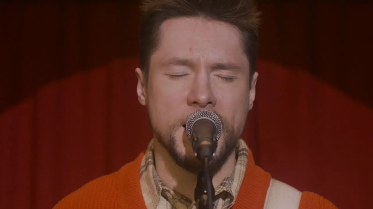 Close Up View Of The Microphone Against Red Curtain On Stage