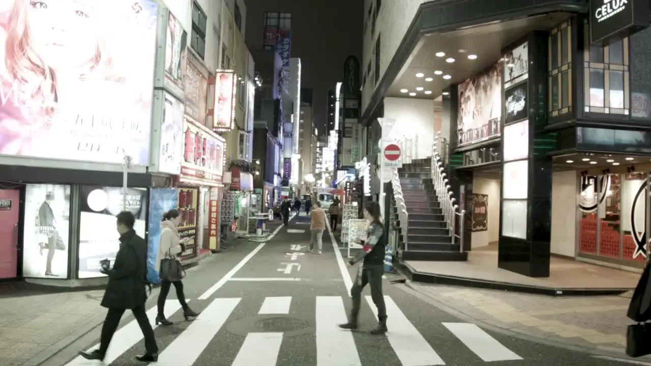 Gentleman companion clubs on Shinjuku City at Hanamichi Street at night with locals walking by Handheld shot