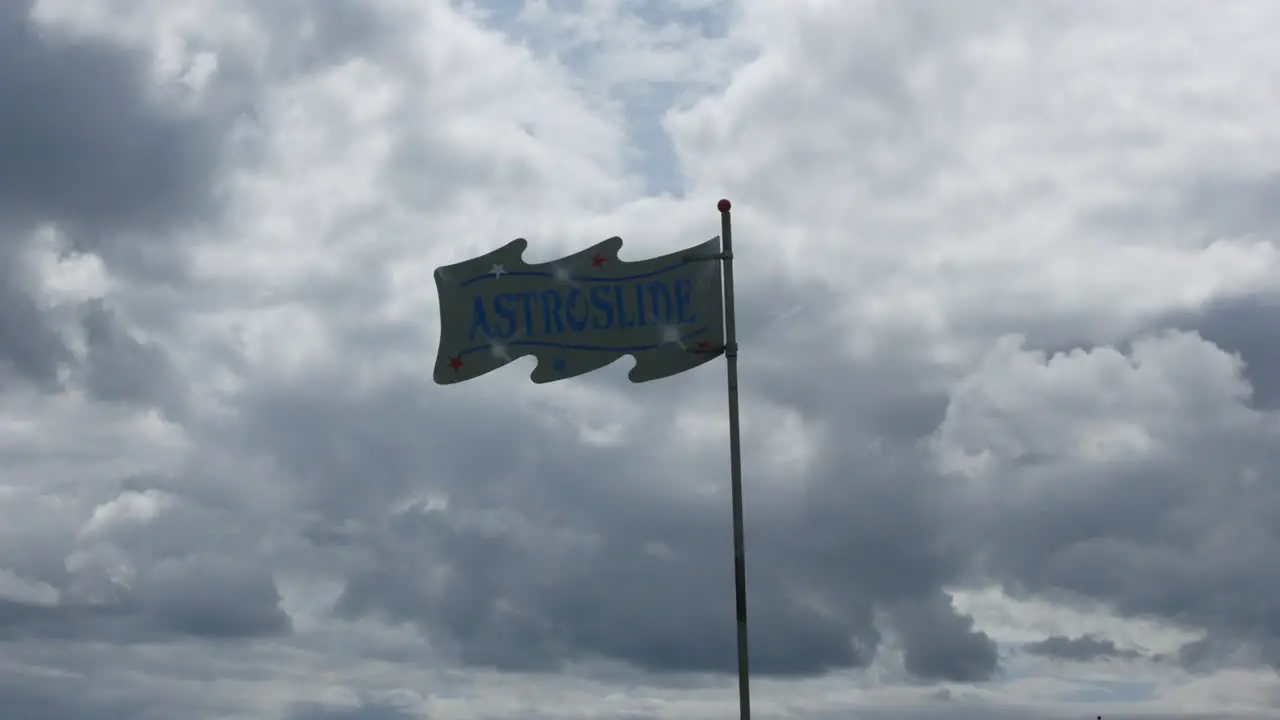 An astro slide sign on a flagpole on a cloudy day