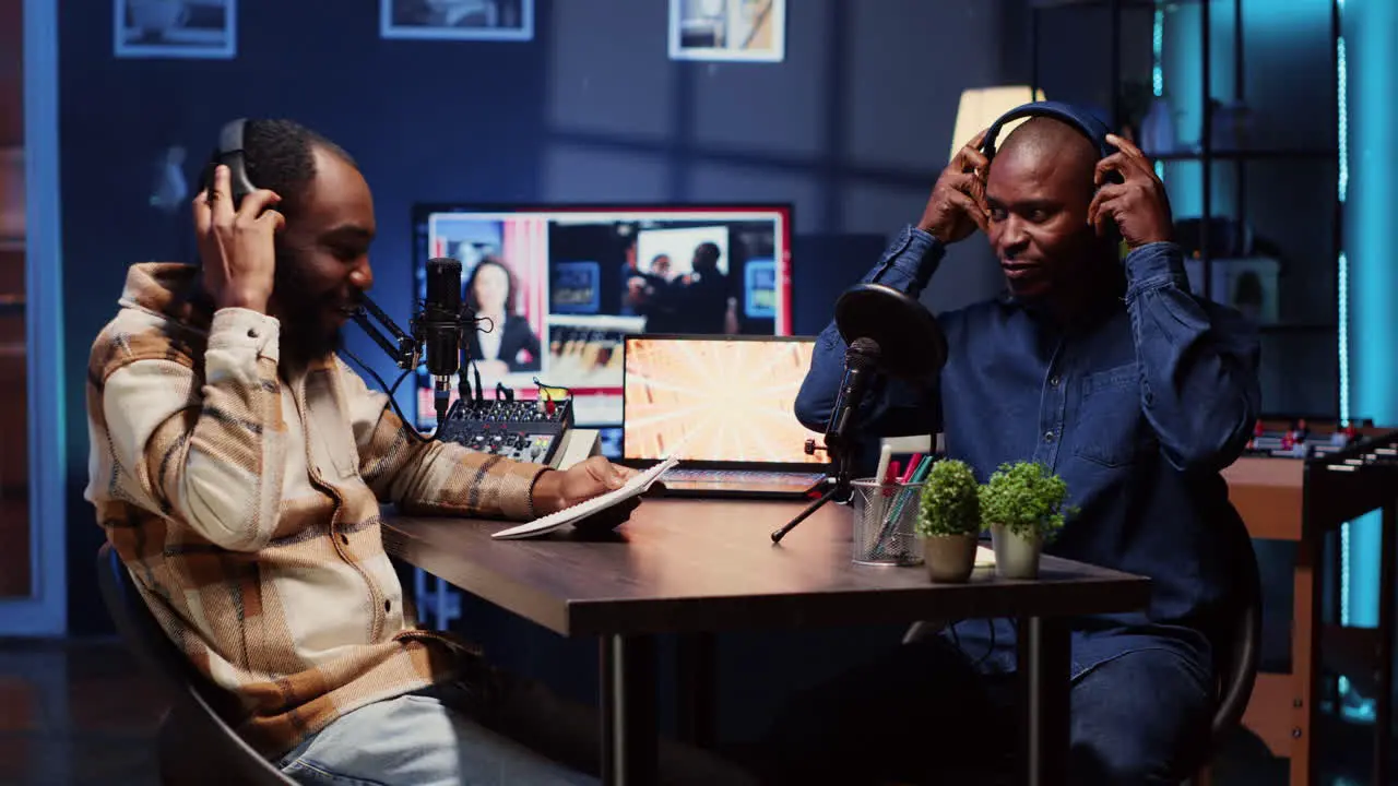 Podcast presenter having live discussion with man using headphones to review music together