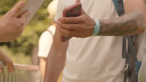 Close Up Shot of Festival Goers Showing Electronic Tickets to Security Guard