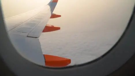 View From Plane Window Of Clouds On Flight To Summer Holiday Vacation