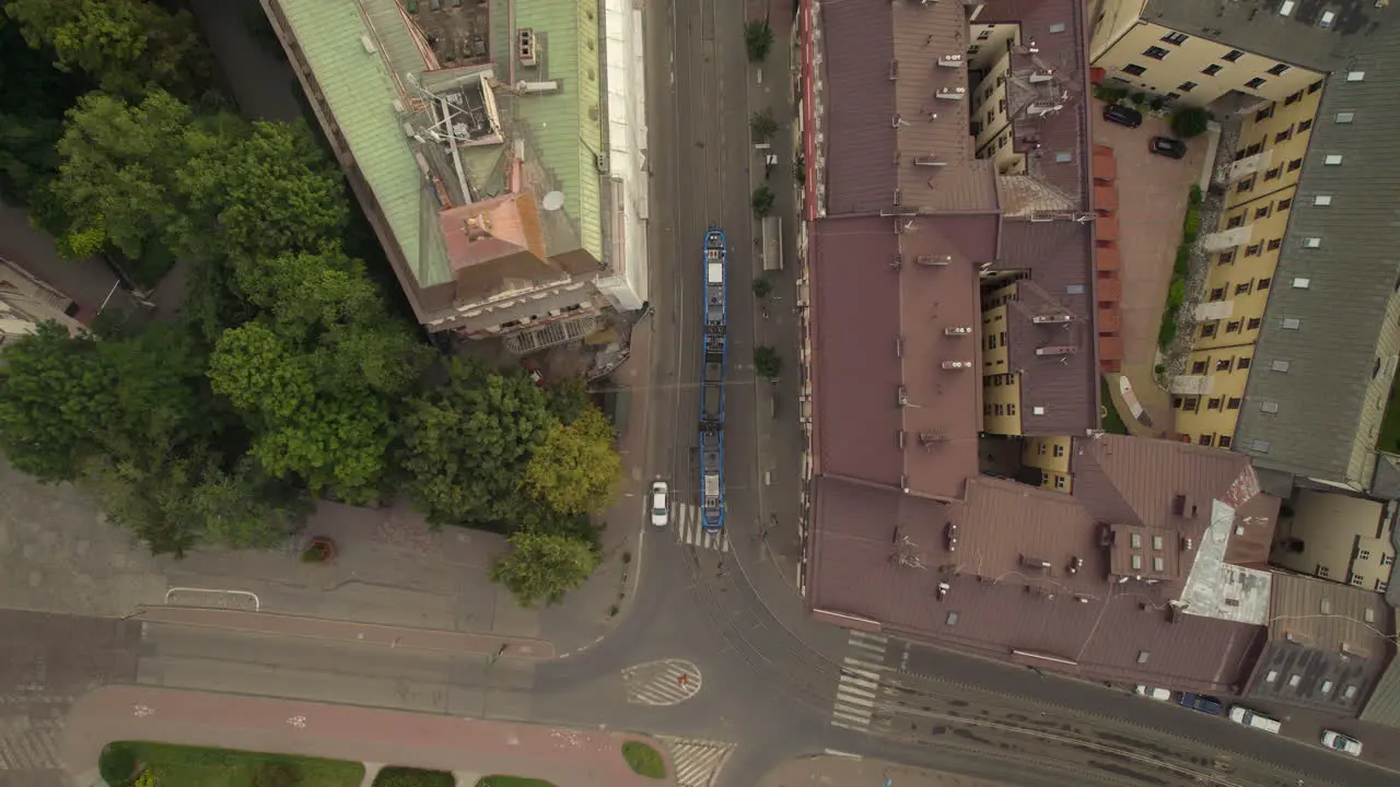 Tram turning around the corner in Krakow center Poland aerial top down view