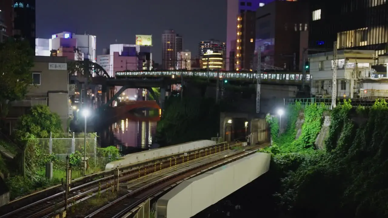 Long JR Train arrives at Station in Akihabara District of Tokyo at Night 4k