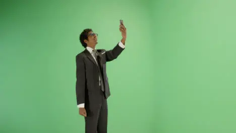 Annoyed man trying find phone signal on green screen