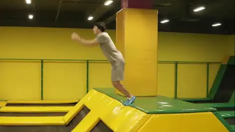 Young sportive boy having the time of his life enjoying jumping on trampoline Performing handspring flips