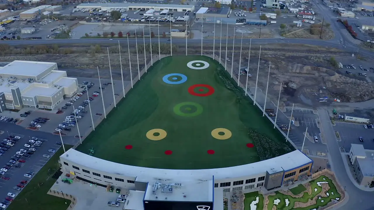 Aerial view moving from the front entrance toward the back of the new Top Golf in Vinyard Utah during dusk