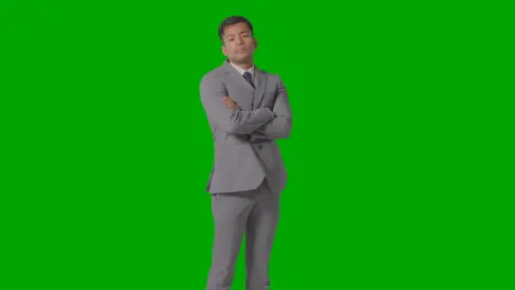 Three Quarter Length Portrait Of Serious Businessman In Suit Folding Arms Against Green Screen 1