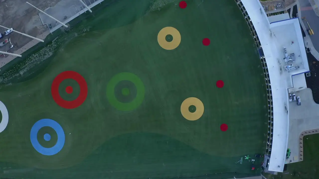 Descending top-down drone shot above the new Topgolf driving range at dusk located in Vinyard Utah