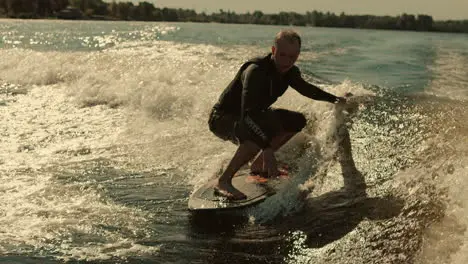 Man surfing on waves in slow motion Wake surfing rider enjoy waves