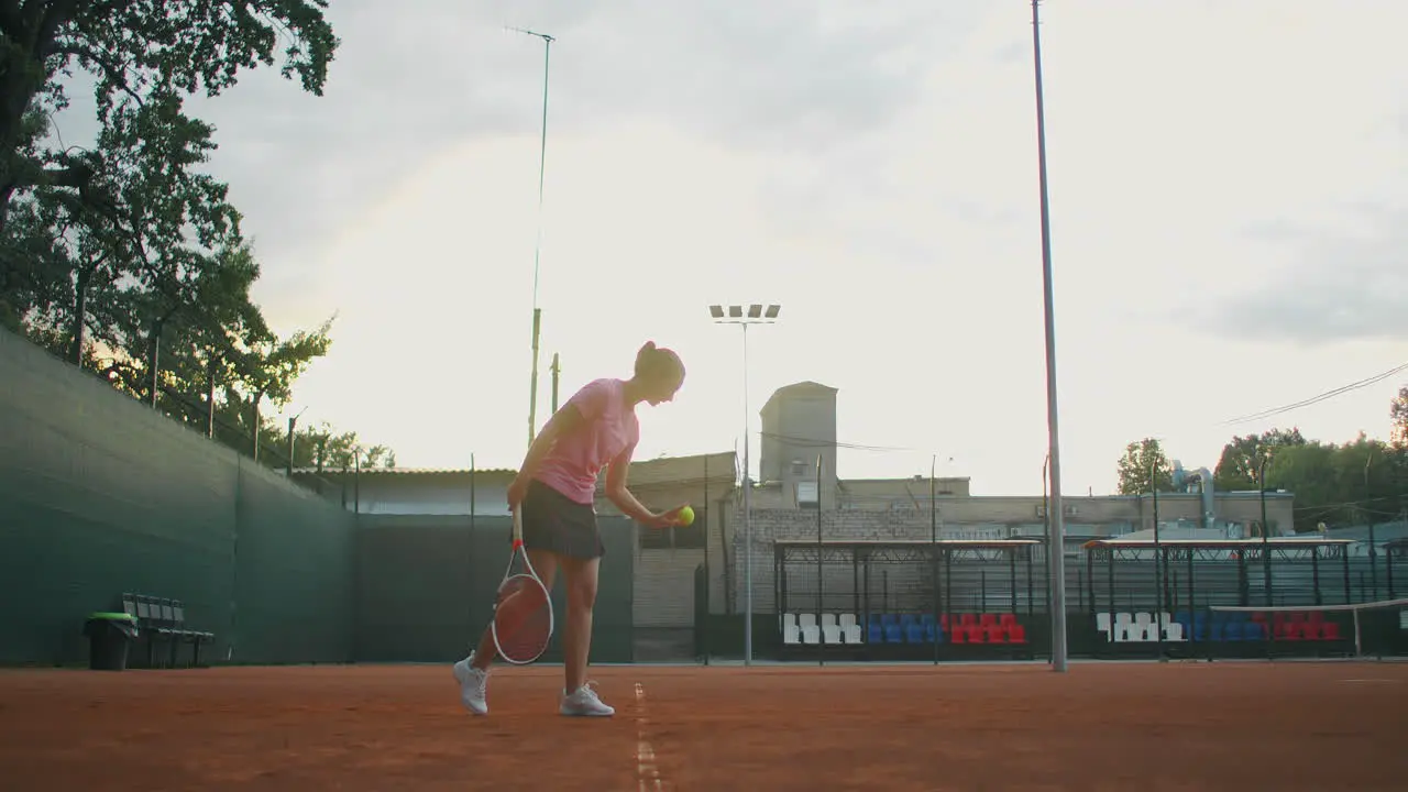 The girl on the central service line repeatedly knocks the ball on the court catches the ball with her hand and serves The general plan