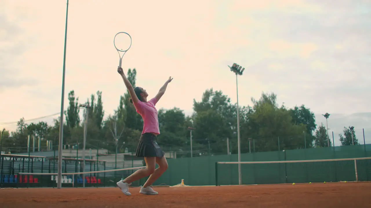 Slow motion Young Caucasian teenager female tennis player serving during a game or practice Tennis Player Serving On The Clay Court