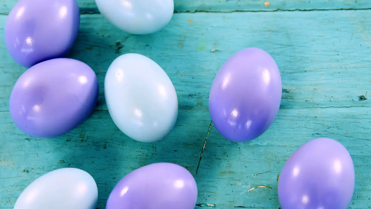 Blue and purple painted Easter eggs on wooden surface