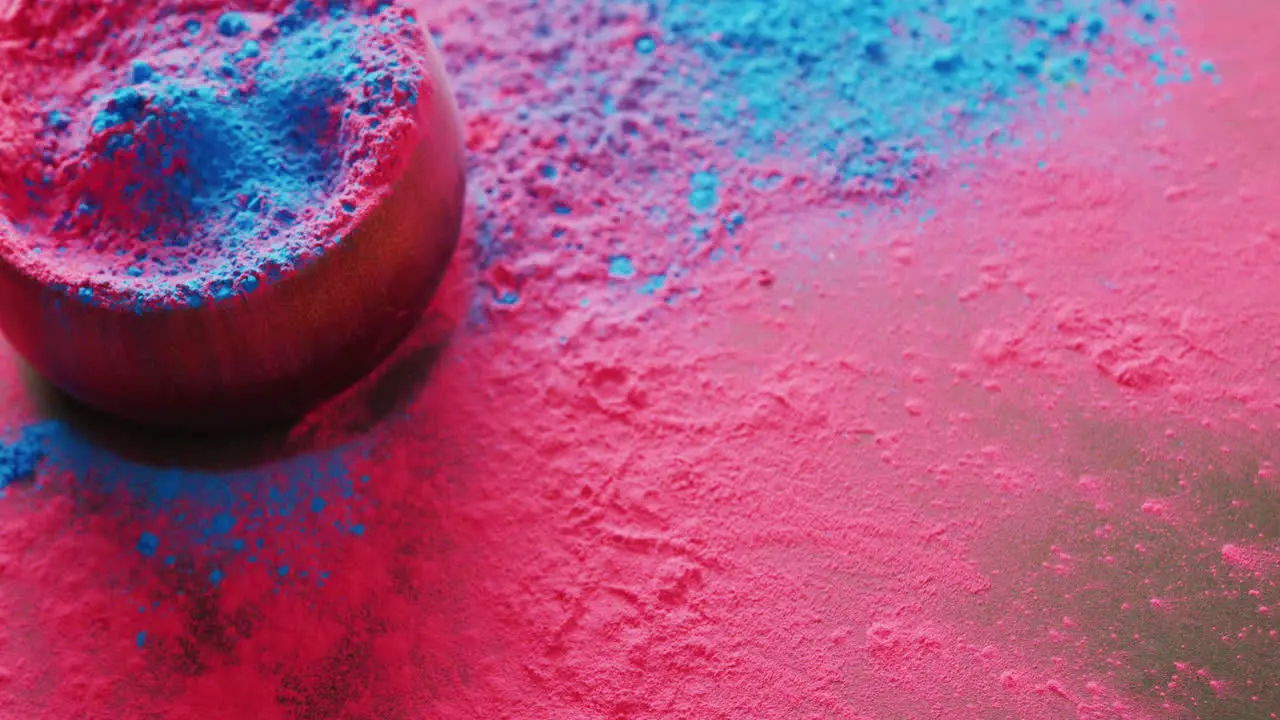 Video of multi coloured powders and bowl with copy space on black background