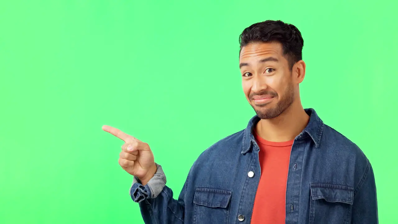 Face man and hand pointing to green screen studio