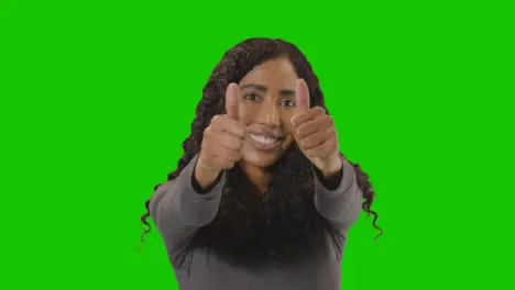 Studio Portrait Shot Of Woman Giving Double Thumbs Up Sign Against Green Screen 1