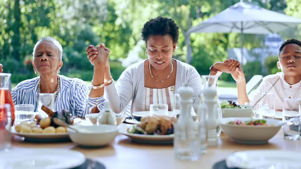 Family hands and praying in outdoors for lunch