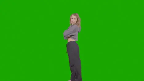 Full Length Studio Portrait Of Young Woman With Attitude Against Green Screen