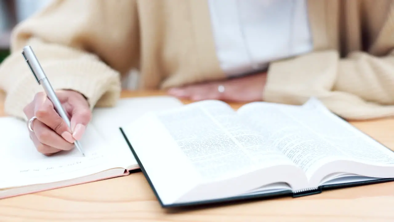 Hands writing and book for bible study